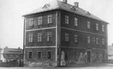 ulice Nerudova - budova první šluknovské školy postavené roku 1814, na její zdi byla morová deska, budova byla 1992 zbourána, deska byla přesunuta na kostel